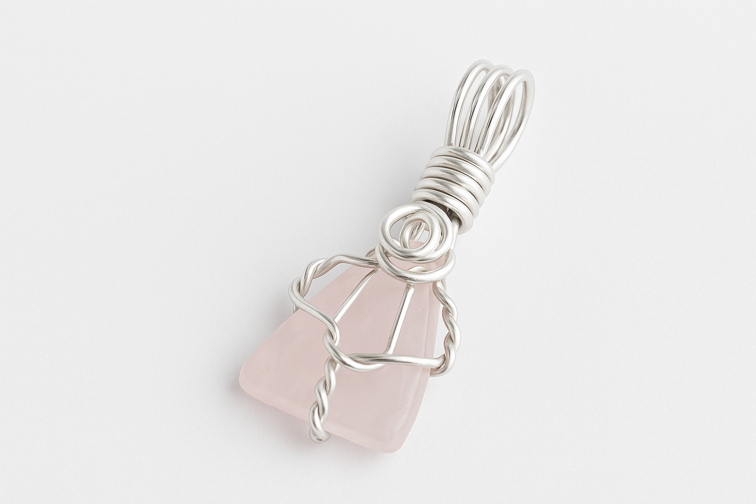 Rose Quartz pendant on white surface with natural lighting
