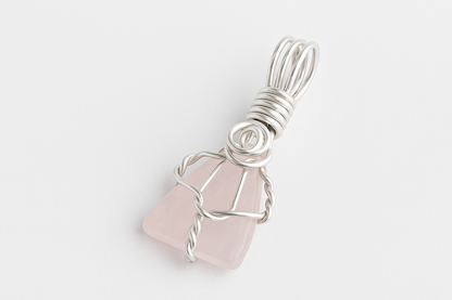 Rose Quartz pendant on white surface with natural lighting